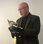 Kokoelmaintendentti Jouni Kuurne esittelee Johan Fabian Fincken valmistamaa hopeakannua vuodelta 1858, jonka Kansallismuseon ystävät lahjoittivat Kansallismuseon kokoelmiin. Kuva: Matti Heimonen